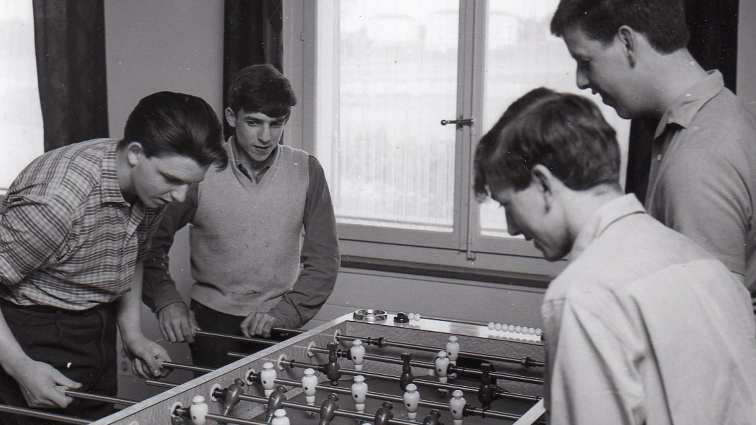 Photo d'archive noire et blanche de jeunes jouant au baby-foot.