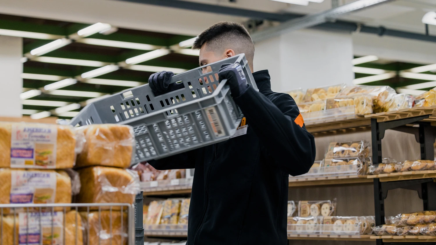 Jeune apprenti remplissant les stocks d'un supermarché.