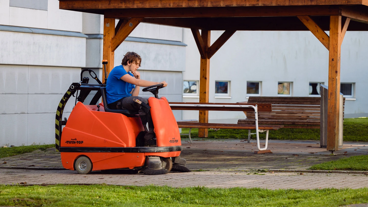 Jeune apprenti utilisant une machine de nettoyage en extérieur.