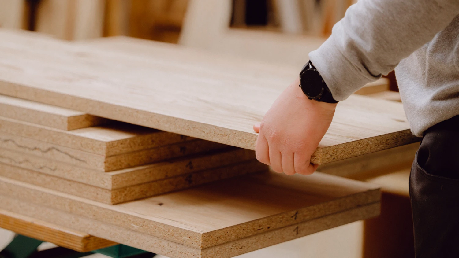 Jeune apprenti portant une planche en bois.