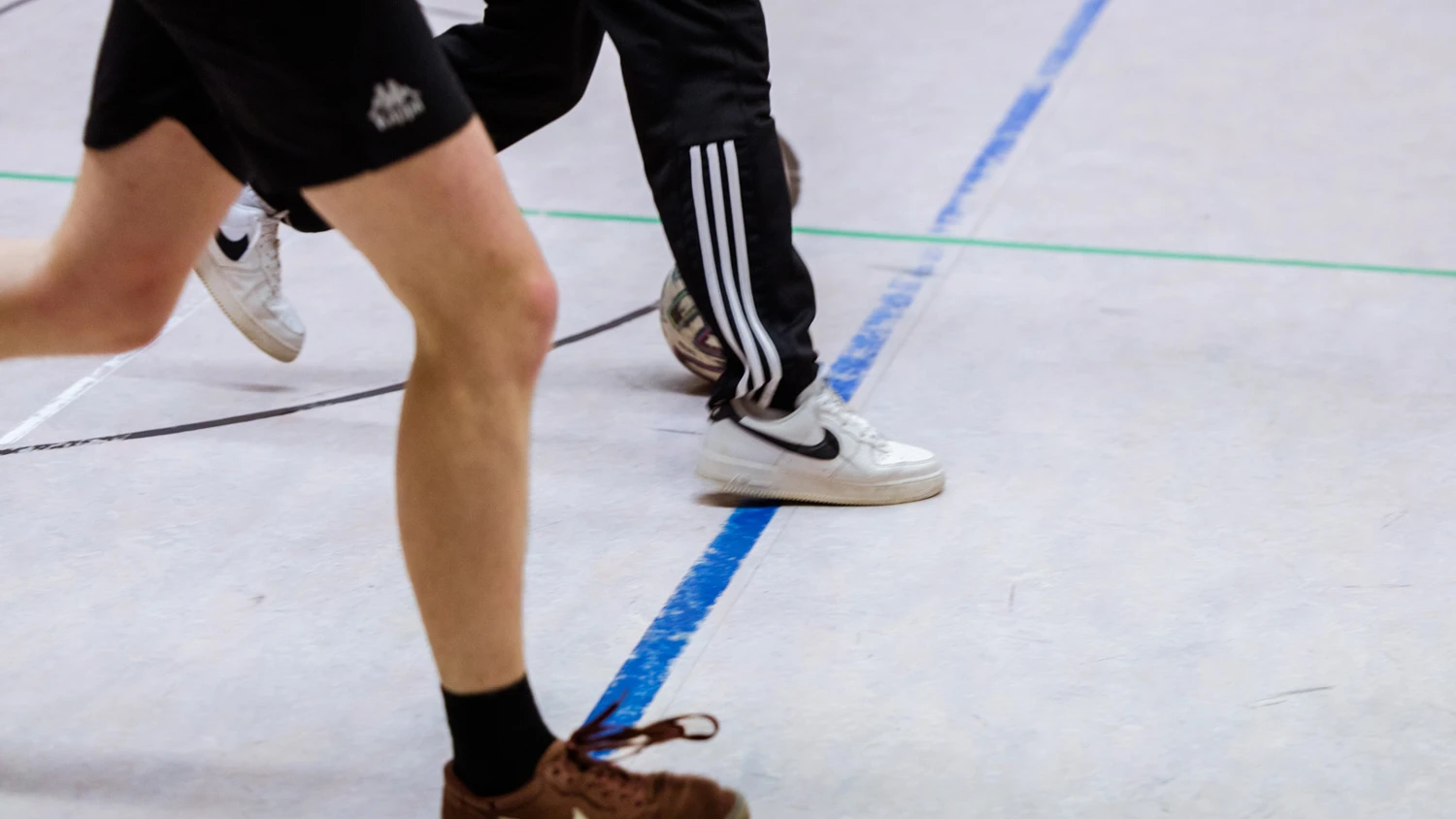 Jeunes apprentis jouant au foot dans une salle de gymnastique.