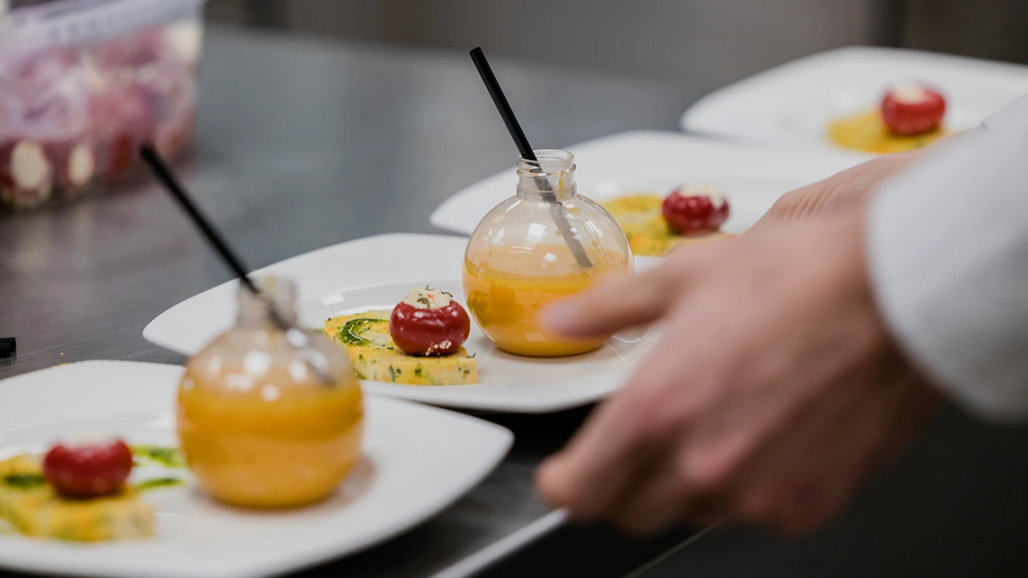 Junger Lehrling nimmt die Dessertteller und bringt sie zu den Kunden.