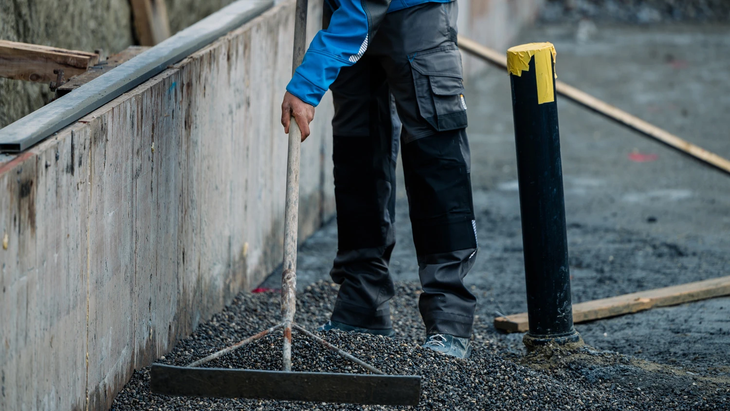 Junger Lehrling, der auf einer Baustelle arbeitet.